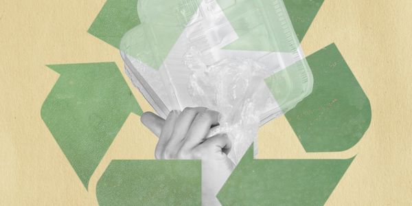 Hand holding plastic waste inside a green recycling symbol.