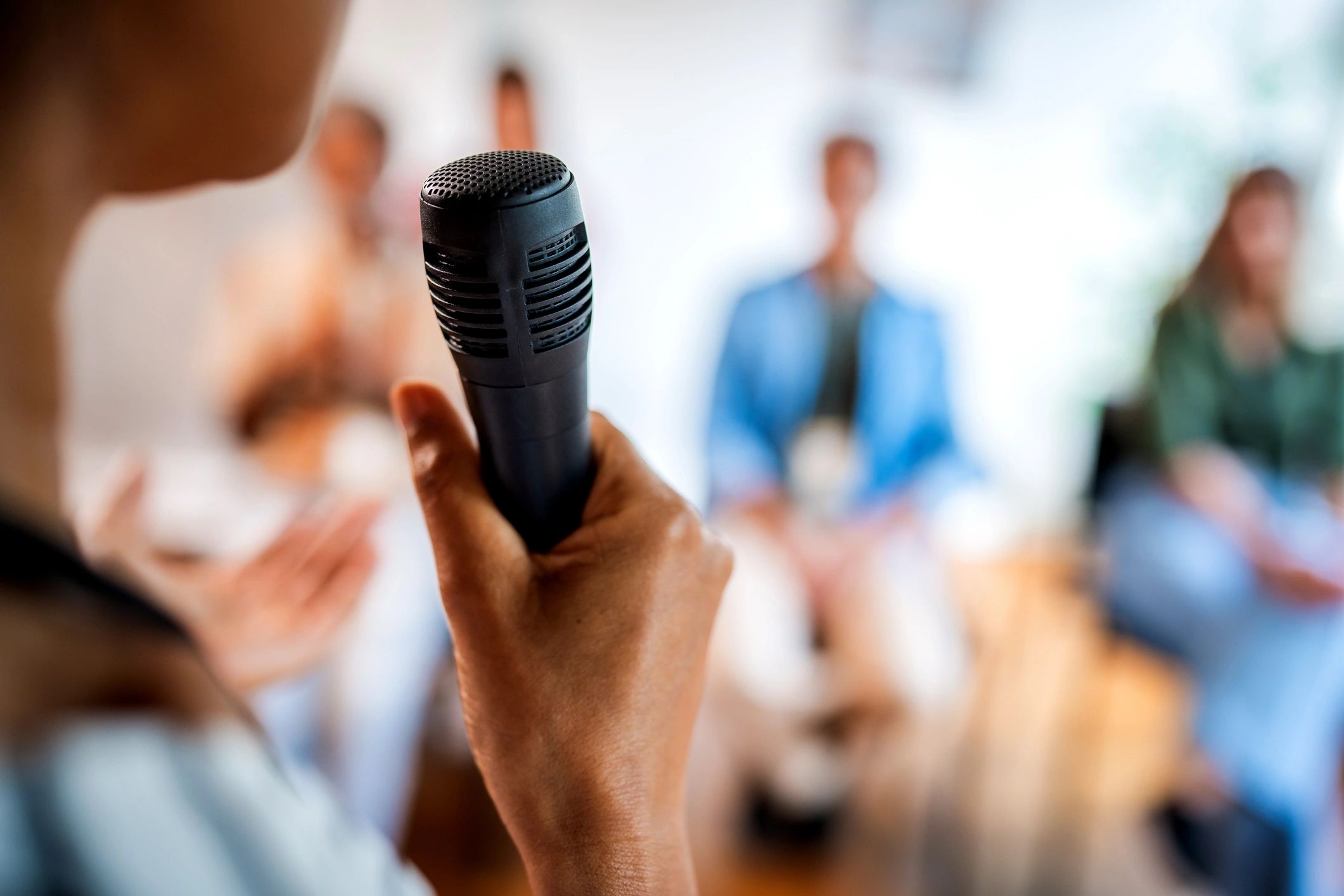 Person holding a microphone in a presentation.