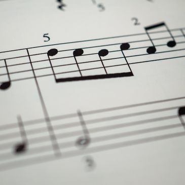 Close-up of sheet music with notes and numbers.