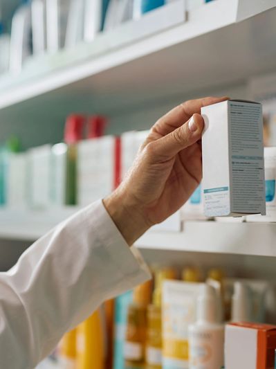 Person holding a skincare product box in a store.
