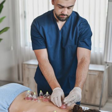 Therapist performing cupping therapy on a patient's back.