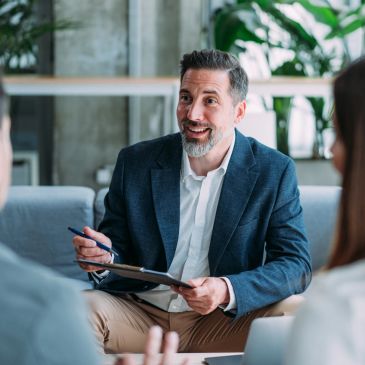 Businessman discussing with clients in modern office.