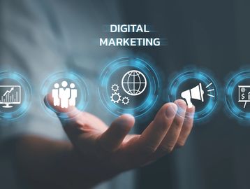 Hand holding digital icons representing digital marketing concepts.