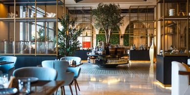 Cozy and modern restaurant interior with blue chairs and wooden tables.