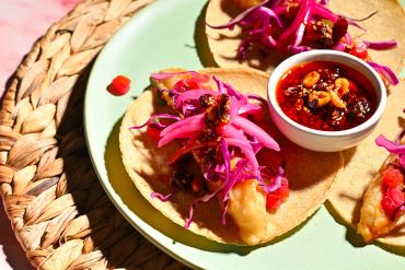 Tacos with fried filling and purple cabbage slaw.