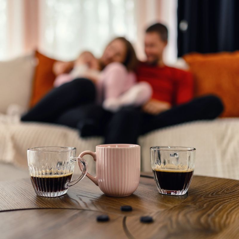 Happy family enjoying morning coffee together at home. Focus on the foreground