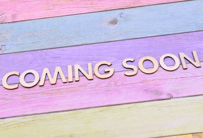 Wooden letters spelling "COMING SOON" on colorful wooden planks.