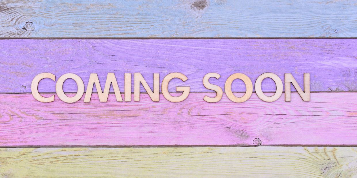 Wooden letters spelling 'COMING SOON' on colorful wooden planks.