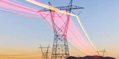 Power lines with light trails at sunset.