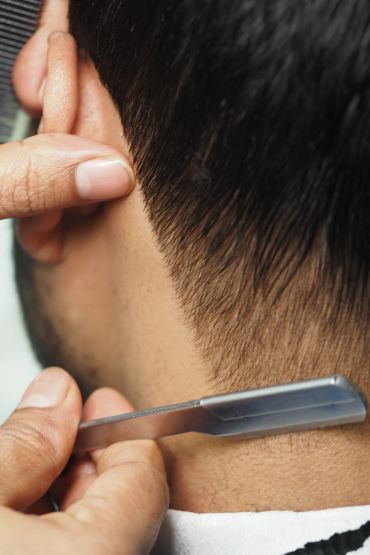 A man getting a close shave at the nape of the neck.