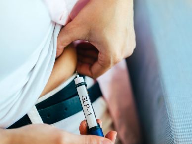 Person administering a GLP-1 injection in their abdomen.