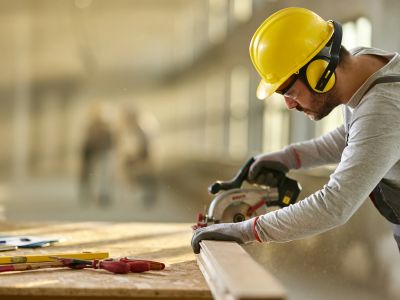 Construction worker cutting wood safely.