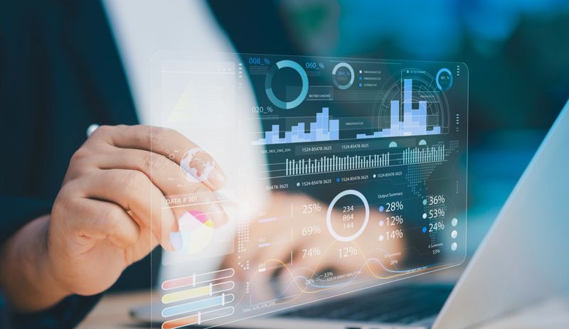 Professional businessman analyzing financial data analytics, key performance indicators, and business metric graphics on a futuristic virtual screen display during a corporate meeting in an office.