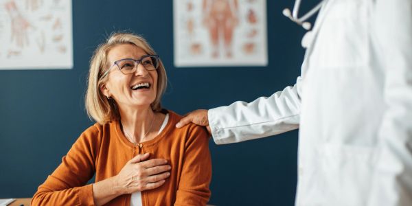 Happy woman interacting with doctor in clinic.