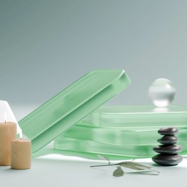 Accessoires de spa avec pierres, bougies et plateaux verts.
