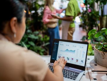 Person working on laptop with data analytics.