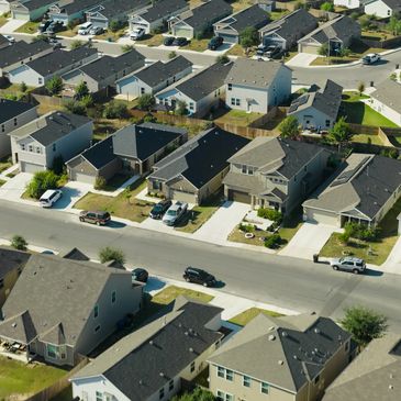 Aerial view of suburban neighborhood with houses and cars.