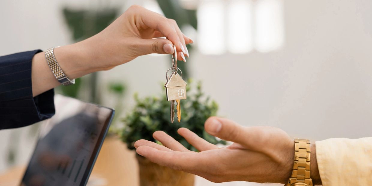 Someone handing house keys to someone else