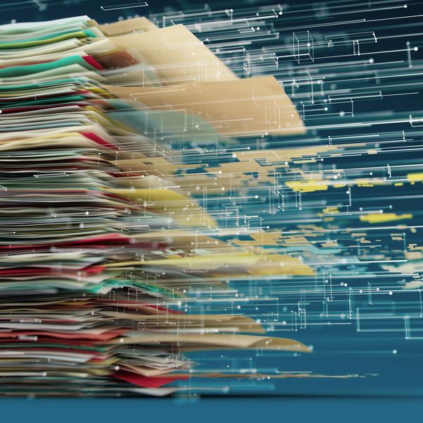 Stack of documents transitioning to digital data.