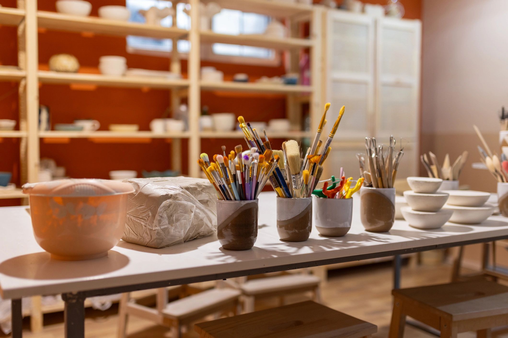 Art brushes organized in containers on a table.