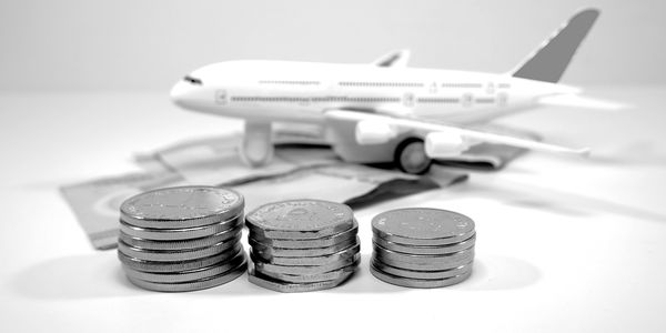 Stacks of coins with a toy airplane in the background.
