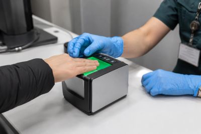 Fingerprint scanning at a checkpoint desk.