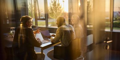 People having a meeting in a glass-walled room.