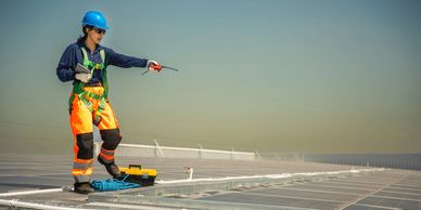 Trabajador en techo instalando paneles solares.