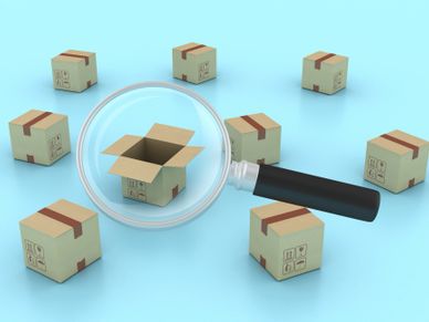 Magnifying glass highlighting an open cardboard box among closed boxes on a blue background.