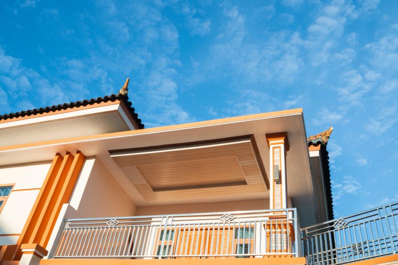 Exterior of a contemporary house featuring balcony details and vibrant sky background.