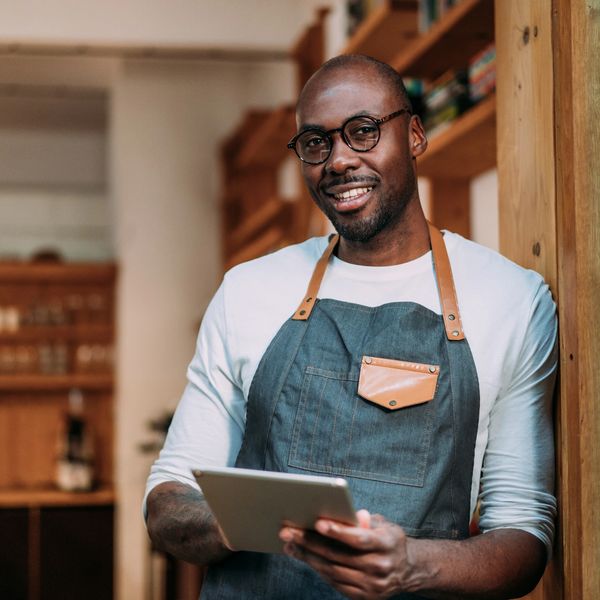 Small business owner standing confidently in his shop.