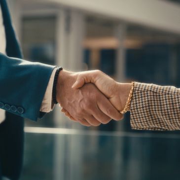 Two people shaking hands indoors.