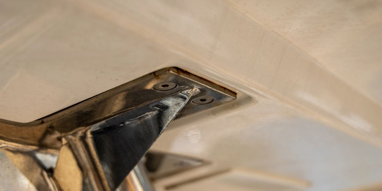 Close-up of a metallic bracket attached to a beige surface.