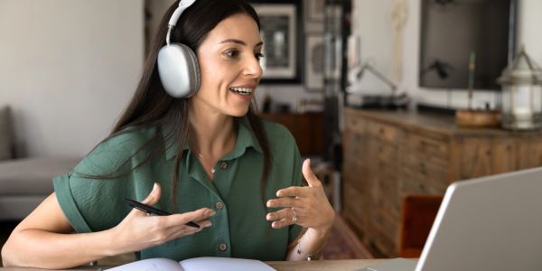Woman video chatting with headphones on.
