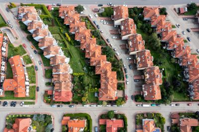Aerial view of a neighborhood with rows of houses and green lawns.