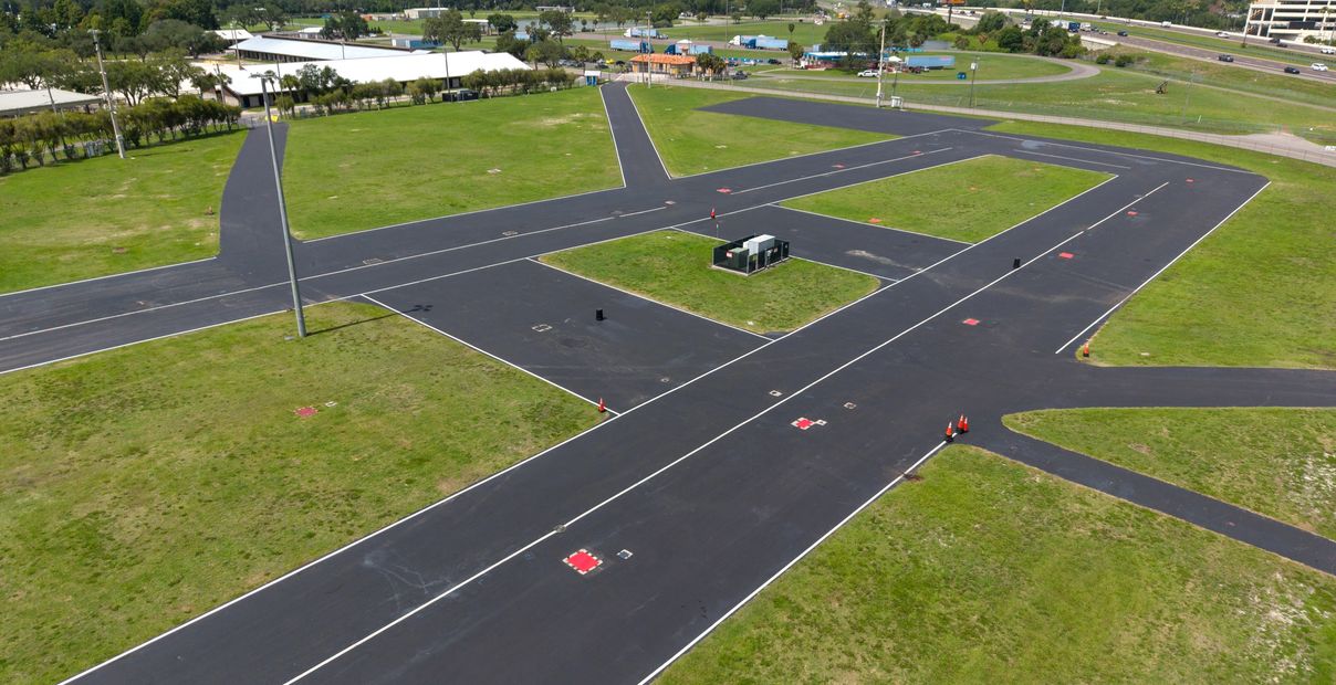 Aerial view of a small airfield runway and taxiways surrounded by grass.