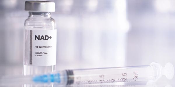 A vial labeled NAD+ with a syringe.