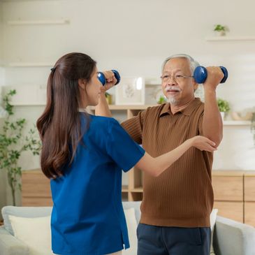 Elderly man lifting dumbbells with assistance from a caregiver.