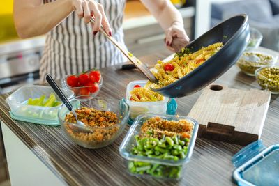 Dietitian Nutritionist preparing pasta meal in containers.
