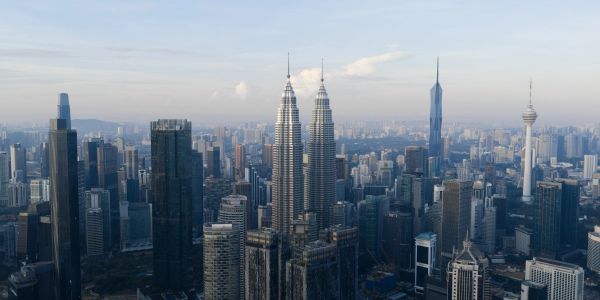 Skyline of a city with twin towers prominently visible.