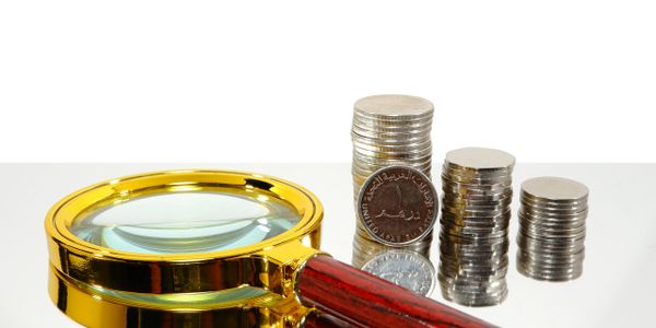 Magnifying glass and stacks of coins.