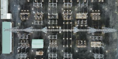 Aerial view of an electrical substation with transformers and power lines.