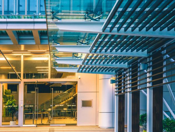 Modern building entrance with glass and metal canopy.