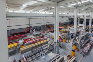 Interior de uma fábrica organizada com equipamentos industriais.