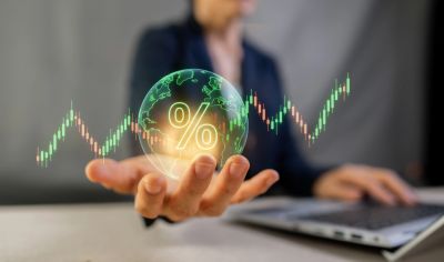 Person holding a glowing percentage symbol with financial chart.