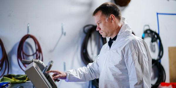 Man using a touchscreen device in a workshop.