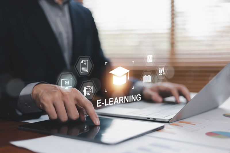 E-learning and online education concept featuring a professional using tablet and laptop with digital learning interface, virtual training, online courses, knowledge management, and remote education
