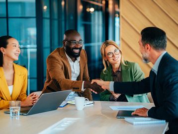 Business meeting with handshake and smiles.