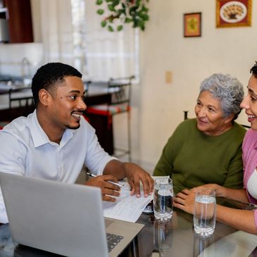 Senior care advisor meeting with an older couple and family member at home.