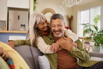 Happy older couple embracing on a couch.